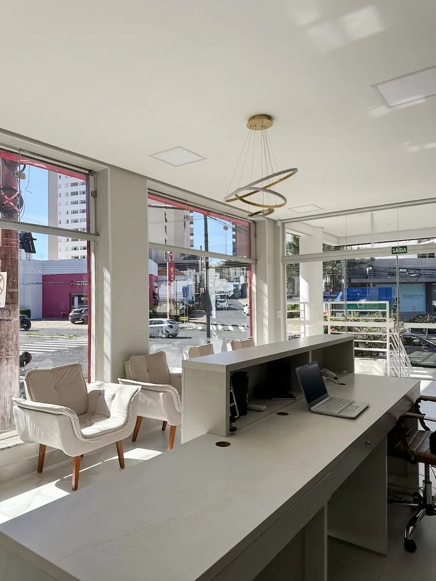 Recepção da Clínica Oral Sorriso, com poltronas junto à vitrine