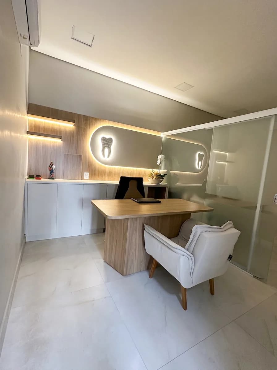 Sala de consulta da Clínica Oral Sorriso, com mesa de atendimento